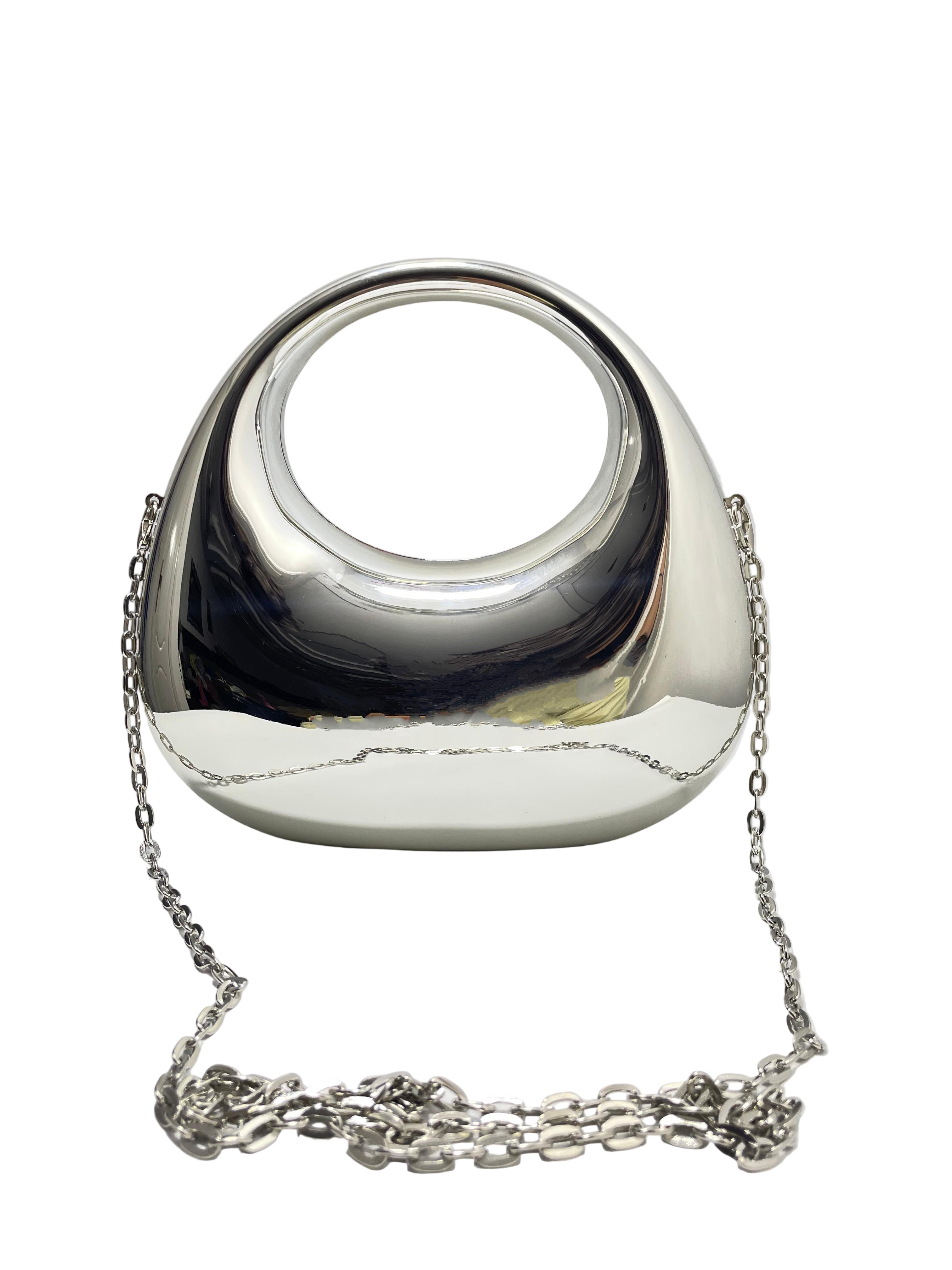 Silver handbag with chain strap on a white surface
